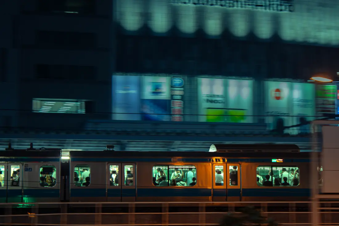 A commuter train sharply framed against a motion-blurred city